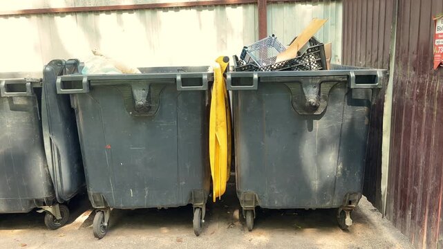 Overflowing Industrial Waste Container Filled with Cardboard and Plastic Crates at Recycling Facility