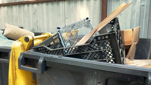 Overflowing Industrial Waste Container Filled with Cardboard and Plastic Crates at Recycling Facility