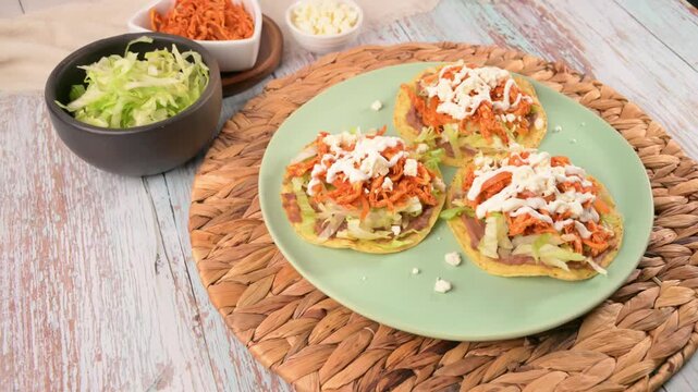 Mexican shredded chicken tostadas topped with fresh cheese and sour cream