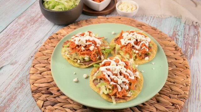 Traditional Mexican chicken tinga tostadas with lettuce, cream, and cheese