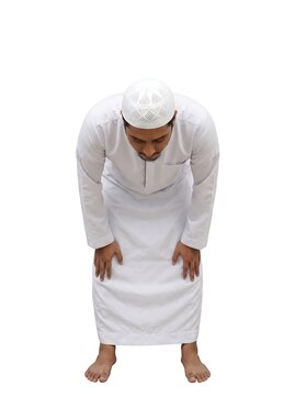 Muslim man performing ruku prayer in traditional clothing
