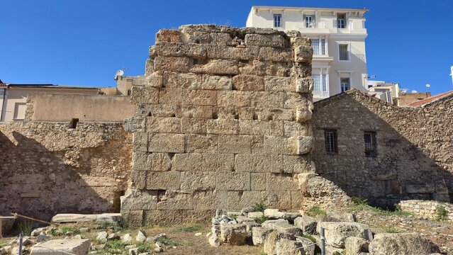 Athens, Greece - 22 June 2026. South wall of the Early Christian Tetraconch beside Hadrian's Library, with ashlar blocks, later masonry, fallen stone fragments, and nearby modern buildings.