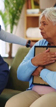 Photo frame, caregiver and comfort old woman with grief for memory, loss and empathy in homecare. Picture, carer and sad senior widower in assisted living for mourning, nostalgia or emotional support