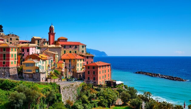 vibrant colorful historic town of ventimiglia alta perched on a hillside overlooking the bright turquoise ligurian sea under a clear blue sky in italy