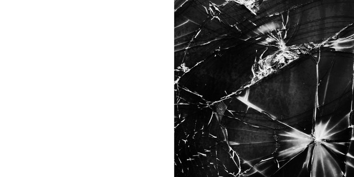 Closeup of shattered glass with sharp fragments and cracks spreading across the surface in a black and white dramatic display