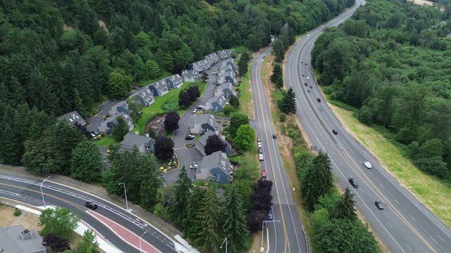 Natural tree buffers enclose residential streets connected by Kent Des Moines Road arterial pathways. Overhead recording captures transition between dense housing density natural tree canopies