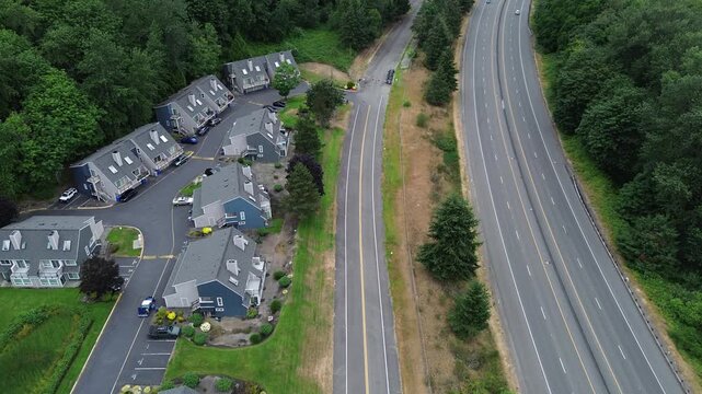 Paved access roads connect secluded townhome clusters near the primary freeway artery. Aerial views document the spatial balance between private living quarters and expansive woodland zones in WA