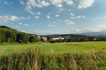 Meadow with a view of the valley and residential houses in Kamienna Góra, Lower Silesia, Poland. © stockcrafter