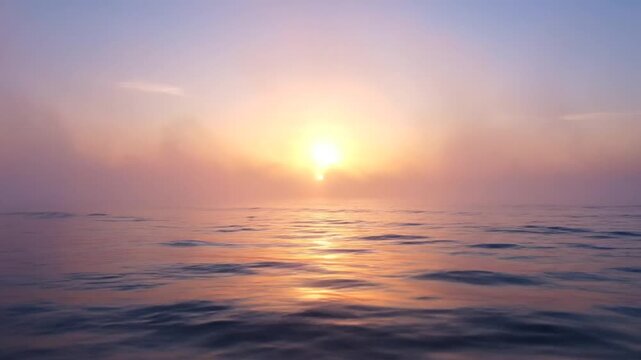 Cinematic sunrise over a calm ocean with thick atmospheric mist and fog obscuring the horizon. Golden light reflects on gentle water ripples under a pastel sky at dawn.