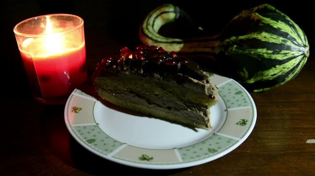 Chocolate with pomegranate cream cake with candle on the board