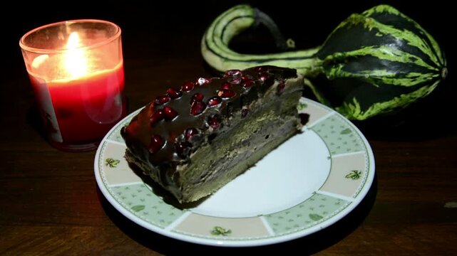 Chocolate with pomegranate cream cake with candle on the board