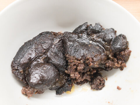 A cooked traditional veres hurka blood sausage served in a bowl, showing its less than perfect appearance after preparation.