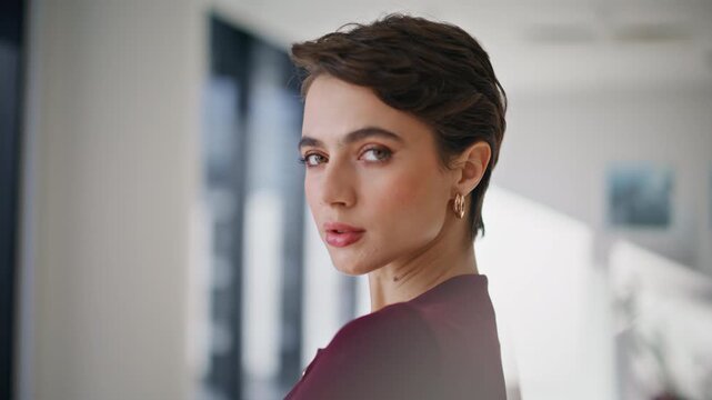 Elegant woman turning head looking at camera. Stylish lady portrait interior