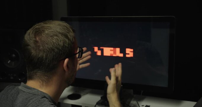 Man reacting in shock while touching a computer monitor displaying a flashing "Virus" warning, illustrating malware infection, cybersecurity threats, computer security, and digital risk.