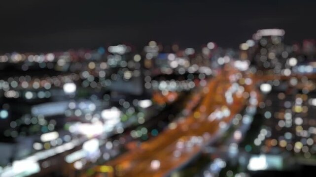 Defocused night timelapse of traffic lights and city bokeh near Tokyo Bay, Japan. Abstract urban skyline with flowing light trails.