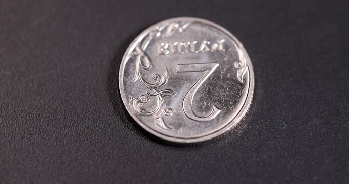 Russian coins of a small denomination of two rubles on a black surface,   money worth 2 rubles of the Russian Federation lies on a black surface, russian money