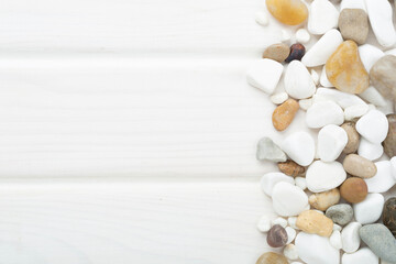 White pebble stones on wooden background, top view © Liami