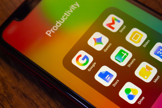 Mexico City, MEXICO - Jul 7 2026 : Close-up of a smartphone showing a Productivity folder with Google app icons including Gmail, Gemini, Google, Slides, Sheets, Docs, Meet, Calendar and Drive.