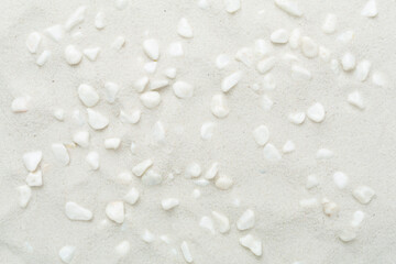 White pebble stones with sand as background, top view © Liami