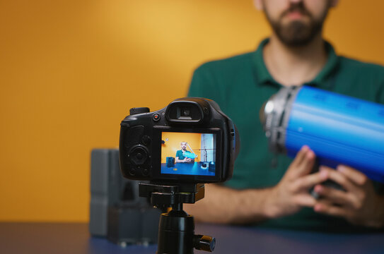 Filmmaker presents studio light for video review during a studio recording, using studio light, lighting review and camera lens as part of a professional creator workflow.
