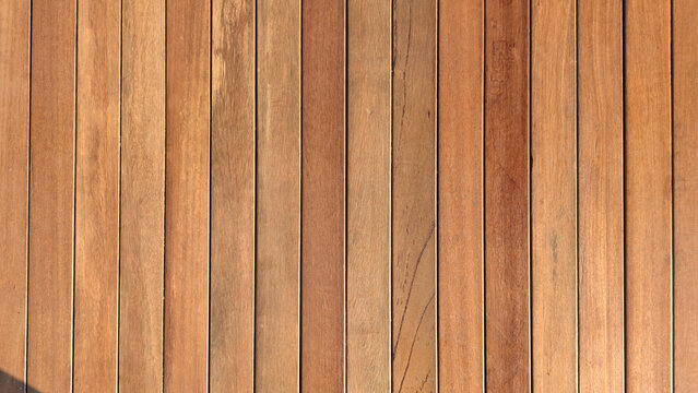 This image shows a wooden deck constructed from narrow, vertical planks with visible natural grain textures