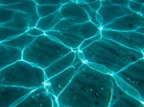 Neon Blue Subsurface Wave Caustics on Sandy Seabed Abstract Underwater Light Patterns