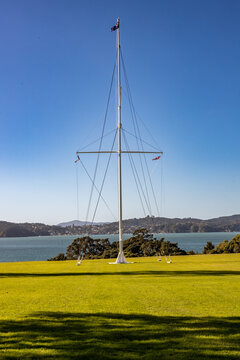 The historic Waitangi Flagstaff at Waitangi Treaty Grounds, Northland, New Zealand, overlooking the Bay of Islands on a clear sunny day.