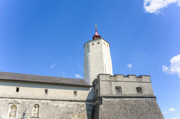 Obraz premium Esterhazy Castle showcases a blend of historic stone architecture with a tall tower under a bright blue sky