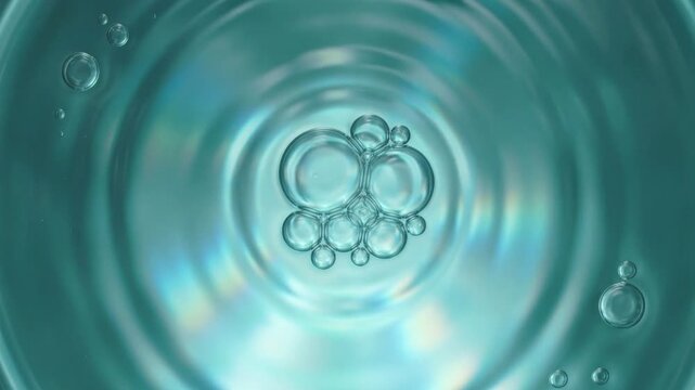 Transparent bubbles floating and rippling in teal liquid for beauty and cosmetic content