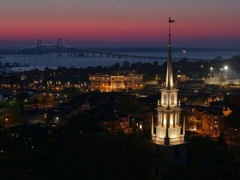 Twilight aerial view of Newport Rhode Island with church steeple and Pell Bridge at dusk. g.