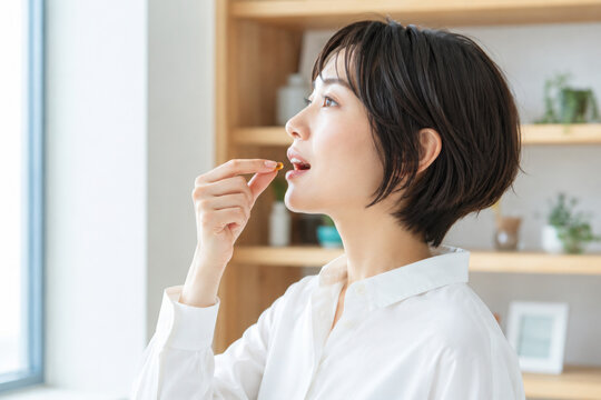 A woman taking medicine. Pharmaceuticals, supplements, over-the-counter medications, generics, vitamins, cold medicine, headache medicine, laxatives.