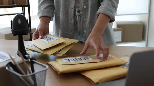 Post office worker with scanner reading barcode at desk indoors, closeup