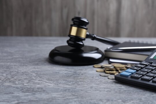 Alimony. Coins, calculator, notebook and gavel on grey table, closeup. Space for text