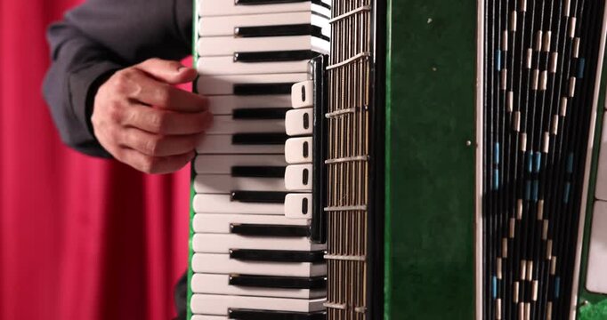 Man playing piano accordion on stage, closeup