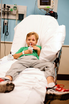 Little boy in hospital bed with stitches over eye
