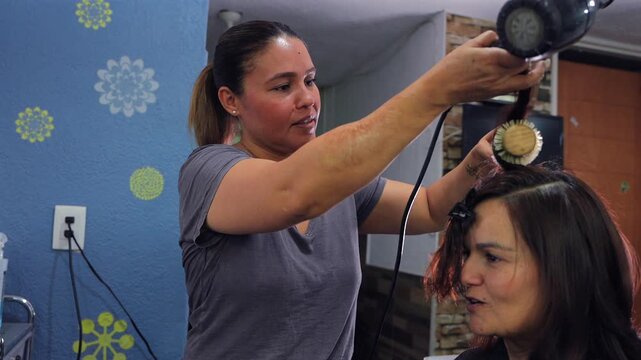 Professional hairdresser styling a client's hair with a blow dryer