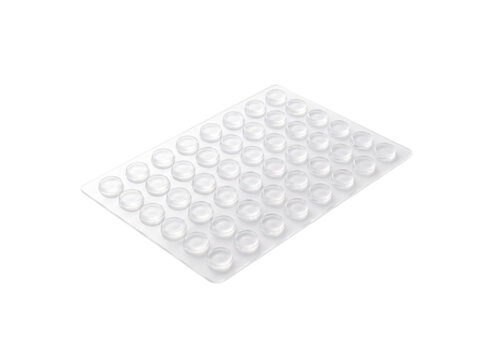 A sheet of clear, round bumper pads, adhesive dots for furniture protection, viewed from a slight angle.