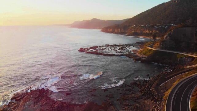 A smooth, eye-level aerial glide following the curved structural profile of the Sea Cliff Bridge as it hugs the dramatic Pacific coastline.