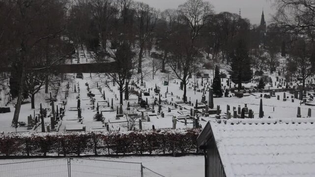 Snow covered cemetery with rows of gravestones in Oslo Norway during winter