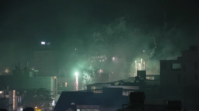 Many Colorful Tet Fireworks Exploding over Night City Skyline