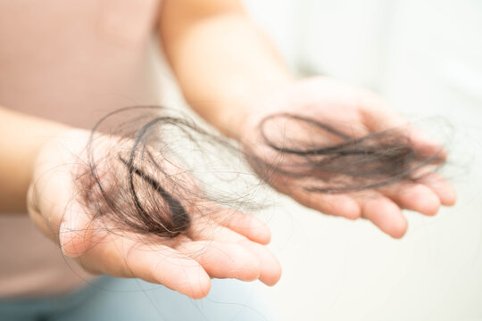 Asian woman have problem with long hair loss attach in her hand.