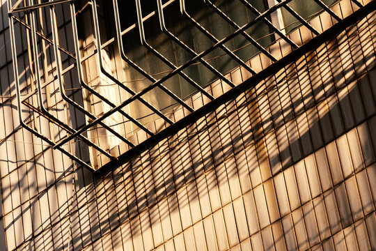 sun light and shadow of wrought Iron window on gray cement building  architecture detail	