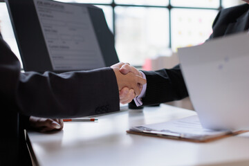 Business people shaking hands in an office, finalizing an agreement and partnership, representing successful collaboration, welcoming a new team member, and achieving a deal © David