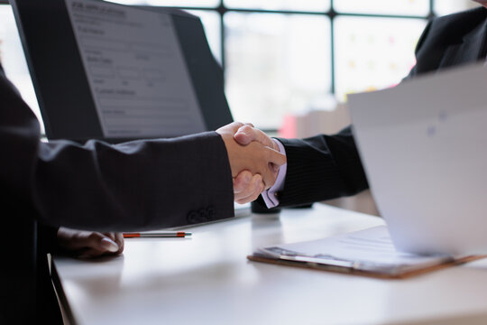 Business people shaking hands in an office, finalizing an agreement and partnership, representing successful collaboration, welcoming a new team member, and achieving a deal