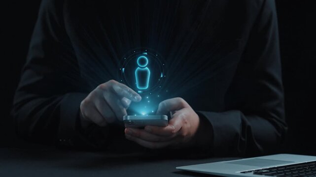 A person interacts with a smartphone, engaging with a futuristic digital interface in a dark environment, symbolizing modern technology and innovation in communication. Qubit