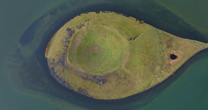 Top-down view of the Skutustadagigar pseudocrater surrounded by Lake Myvatn in Thingeyjarsveit, Northeast Region, Iceland, showcasing a rootless volcanic cone formed by lava interacting with wetlands,