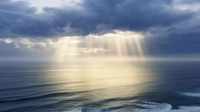 Sunlight rays breaking through dark clouds over the vast ocean water in a calm serene view