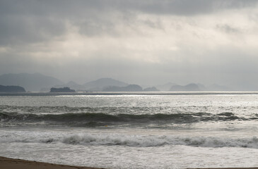 Obraz premium Silhouettes of Distant Islands over a Cloudy Sea in Goheung at Dawn