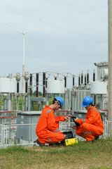 Electrical engineers are checking the operation and power distribution systems within the substation receiving power from the wind farm.  © eakarat