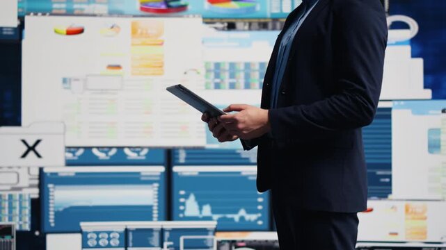 A professional businessman analyzes finance charts and infographics on a digital dashboard, using the data for strategic planning and leadership in a fast-paced corporate economy.